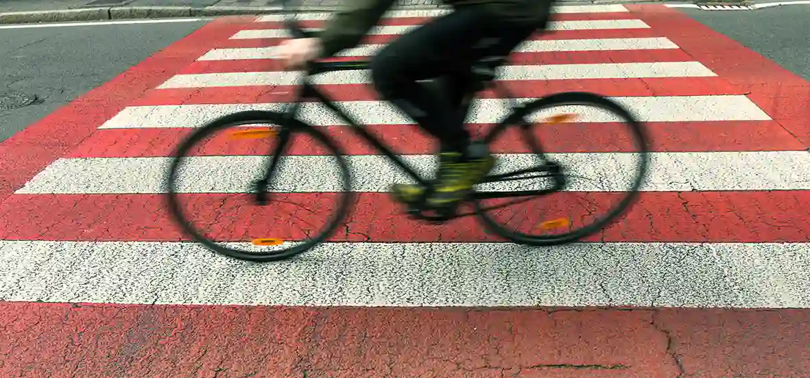 vélo roulant sur un passage piéton, pour illustrer la cohabitation entre les vélos et le milieu urbain